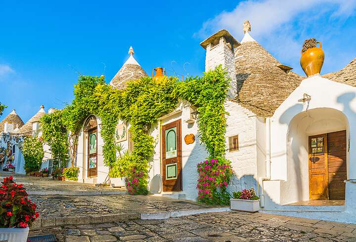 Perinteisiä Trulli-taloja Alberobellossa Italian Apuliassa kesäpäivän paisteessa.