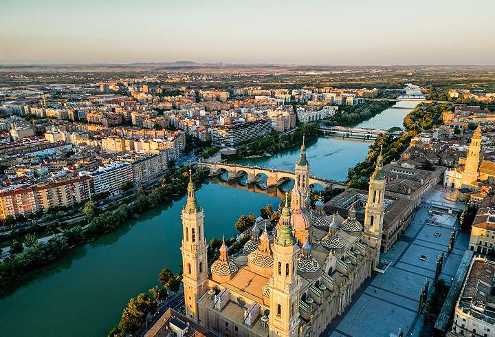 Zaragozan kaupungin siluetti auringonlaskun aikaan, jossa näkymä vanhaankaupunkiin, Zaragozan katedraaliin ja Ebro-joelle.