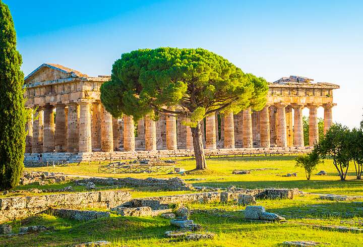 Kaunis näkymä kuuluisille Paestumin temppeleille, arkeologiselle UNESCOn maailmanperintökohteelle, luonnonkauniissa kultaisessa iltapäivän valossa, Salernon maakunnassa Campaniassa Italiassa.