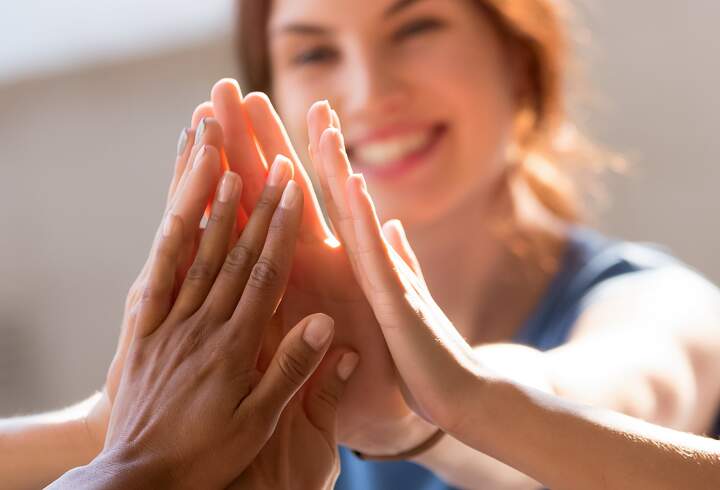 Tiimin jäsenten kämmenet yhdessä onnistumista ja tavoitteiden saavuttamista kuvaten.