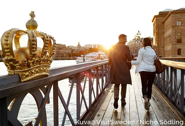Pariskunta kävelemässä sillalla Tukholmassa.