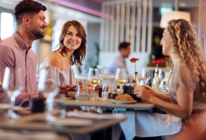 Ystävät ravintolassa syömässä. 