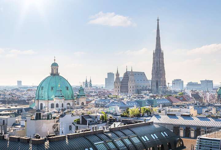 Näkymä yli Itävallan pääkaupungin Wienin, jossa kaupunkisiluetissa näkyy Pyhän Tapanin katedraali aamunkoitteessa.