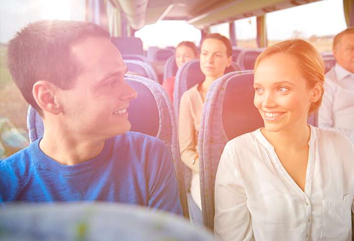Pariskunta bussimatkalla kohti risteilyä. 